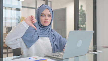 Thumb Down by Woman in Hijab while Working on Laptop
