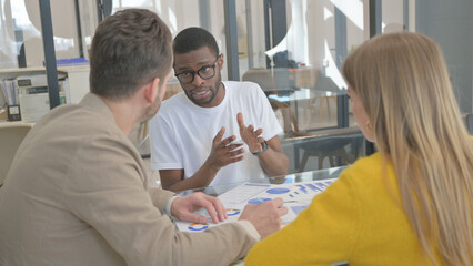 Fototapeta premium Young Mixed Race People Doing Paperwork in Office