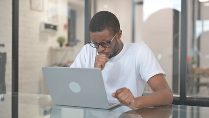 Coughing African American Man while Working on Laptop