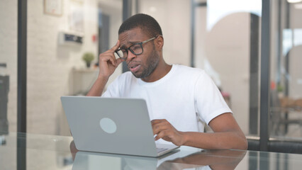 African American Man with Headache Working on Laptop