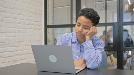 Fototapeta premium Tired Young African Woman Sleeping in Front of Laptop