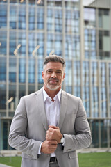 Confident middle aged professional entrepreneur business man ceo executive leader, happy elegant mature businessman manager company owner wearing suit standing outdoors. Vertical portrait. - 777401714