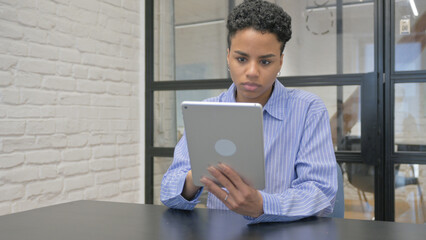 Young African Woman Using Digital Tablet in Office