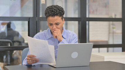 Mixed Race Woman Upset while Reading Contract while Using Laptop