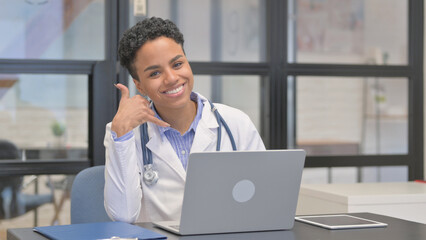 Call me Gesture by Mixed Race Female Doctor While using Laptop