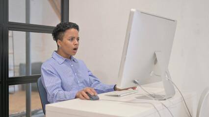 African Woman Reacting to Loss on Desktop Computer - obrazy, fototapety, plakaty