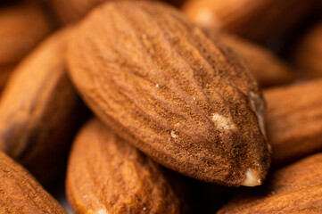 Background of big raw peeled almonds situated arbitrarily.