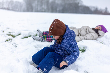 Two little girls playing in the snow. Winter fun for children.