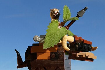 Naklejka premium LEGO Star Wars Tusken raider figure from Tatooine carrying Catnip plant (Nepeta Cataria) leaves, while riding on Banthas bull mount, clear blue skies in background. 