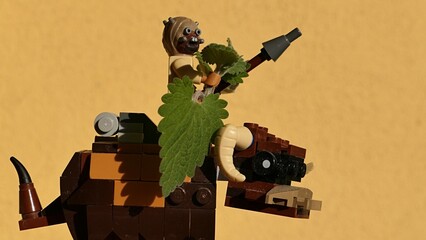 Naklejka premium LEGO Star Wars Tusken raider figure from Tatooine holding his rifle and Catnip plant (Nepeta Cataria) leaves, while riding on Banthas bull mount, yellow wall in background. 