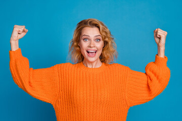Photo of astonished positive woman wear stylish orange clothes hands up glad triumph isolated on...