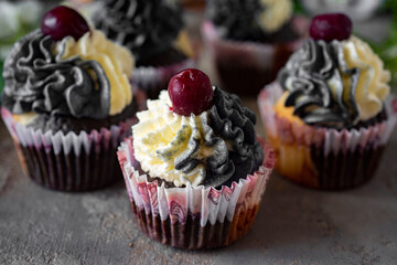 Sweet dessert: vanilla chocolate cupcakes with cherries for breakfast. Close-up