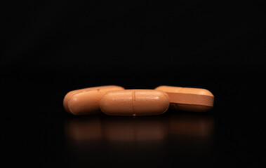 A close up with a group of three pills on a black background, perfect for ornamental or decorative image