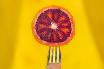 slice of red orange on a fork concept