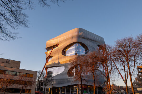 ROCHESTER, MN &ndash; 14 DEC 2023: The new Kellen Building, seen on the Mayo Clinic campus, has a distinct space age architectural design. Seen past trees in morning light, with extended construction lifts 