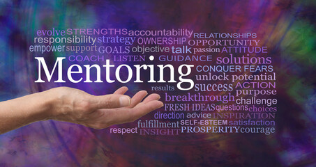 Words associated with the Power of Mentoring - female open palm with the word MENTORING floating above surrounded by a relevant word cloud on a modern abstract multicoloured background
