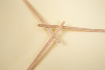 Bamboo wooden sticks demonstrating a reciprocal frame structure, on beige background