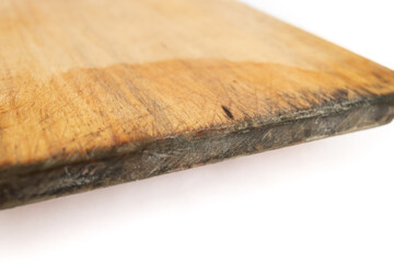 Wooden chopping board with cut marks and black mold, close up on white background