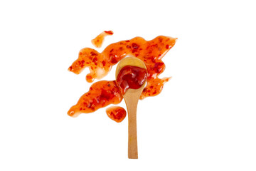 Chili sauce texture smudge and a wooden tea spoon isolated on white background