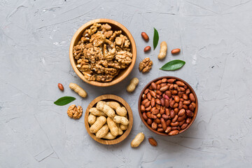 Walnut kernel halves with peanut, in a wooden bowl. Close-up, from above on colored background. Healthy eating groundnut concept. Super foods with copy space