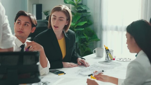 Business woman working and discussing about house model while businessman handed document about architectural model to investor sitting at meeting table with blueprint scattering around. Alimentation.