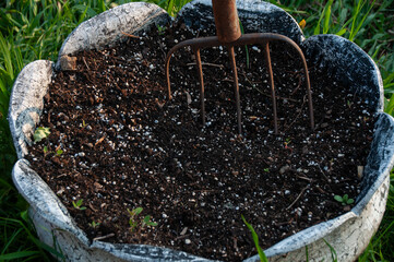A pitchfork stuck in the dirt on a sunny summer day