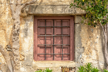 Fototapeta na wymiar Old wooden window on stone wall in Rethymnon. Greece.