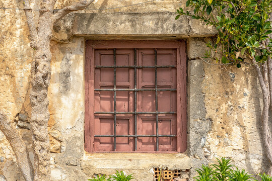 Old wooden window on stone wall in Rethymnon. Greece.