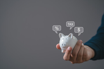 Piggy bank property tax, local development tax concept. Word tax, man holding piggy bank with...