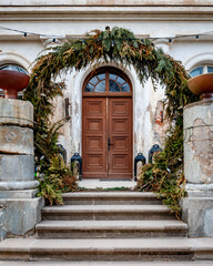The front door of the old Latvian manor Abgunste. The door is decorated by fir branches.