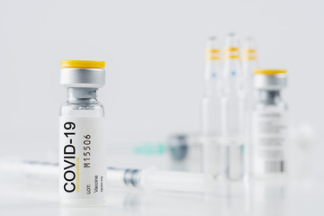 Coronavirus vaccine vial glass with a syringe on white background. Covid-19 medicine vaccination concept. World pandemic concept.