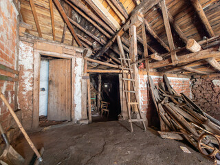 A small room with a ladder and a pile of wood