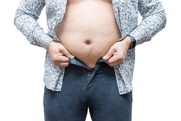 Overweight man with fat belly trying to fasten tight trousers, isolated on white background