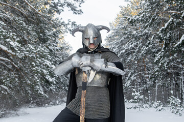 Portrait of a medieval fantasy warrior in a horned helmet, steel cuirass, chain mail with a...