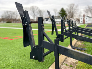 Football blocking sled on a grass turf sports field. Side view of the equipment players use in practice to simulate blocking their opponent. Used to safely reinforce proper tackling technique.