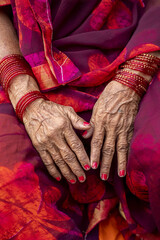 Sitting woman in red clothes and bangles, Daulatabad, Maharashtra, India