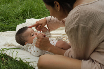 Baby dressed in a light swaddle enjoys time with mom outdoors. This image celebrates life s simple, natural joys.