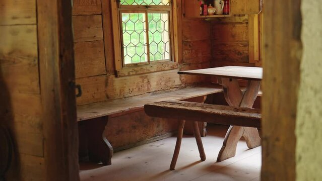 Rustic wooden interior of rural cozy farmhouse, mother and baby entering room inside Swiss Chalet
