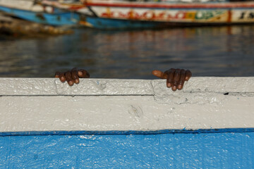 ChildÕs hands on a boat in Ndangane, Senegal - obrazy, fototapety, plakaty