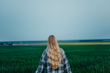 long-haired blonde woman in a field in summer, nostalgia and memories of summer.