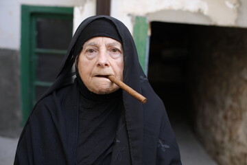 Senior muslim woman smoking a cigar