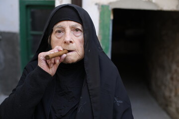 Senior muslim woman smoking a cigar