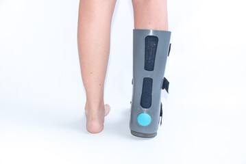 rear view of legs with orthopedic boot, rehabilitation, foot injury, sprain, strain