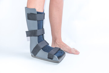 side view of legs with orthopedic boot, rehabilitation, foot injury, sprain, strain
