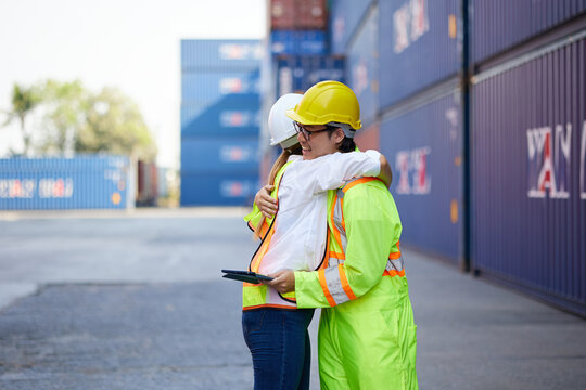 workers or engineers feeling happy from success work and hugging in containers warehouse storage - Powered by Adobe