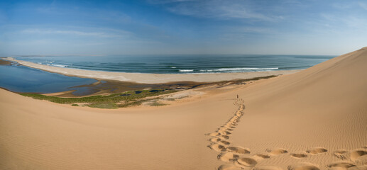 Panoramaaufnahme einer Sanddüne, Sandwich Harbour rechts, Blick auf den Atlantik, Fußspuren im...