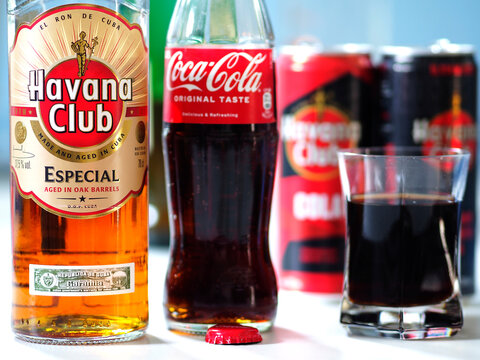 In this photo illustration, a bottles of Havana Club Especial Rum and Coca-Colla  seen displayed on a table.