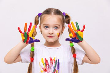 Surprised little cute girl showing painted palm, hands on white background. Children creativity...