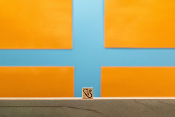 青い十字のマークをしたオレンジ色の背景に聴診器マークのブロックの正面 - obrazy, fototapety, plakaty