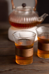 Herbal tea in glass cups, heated teapot